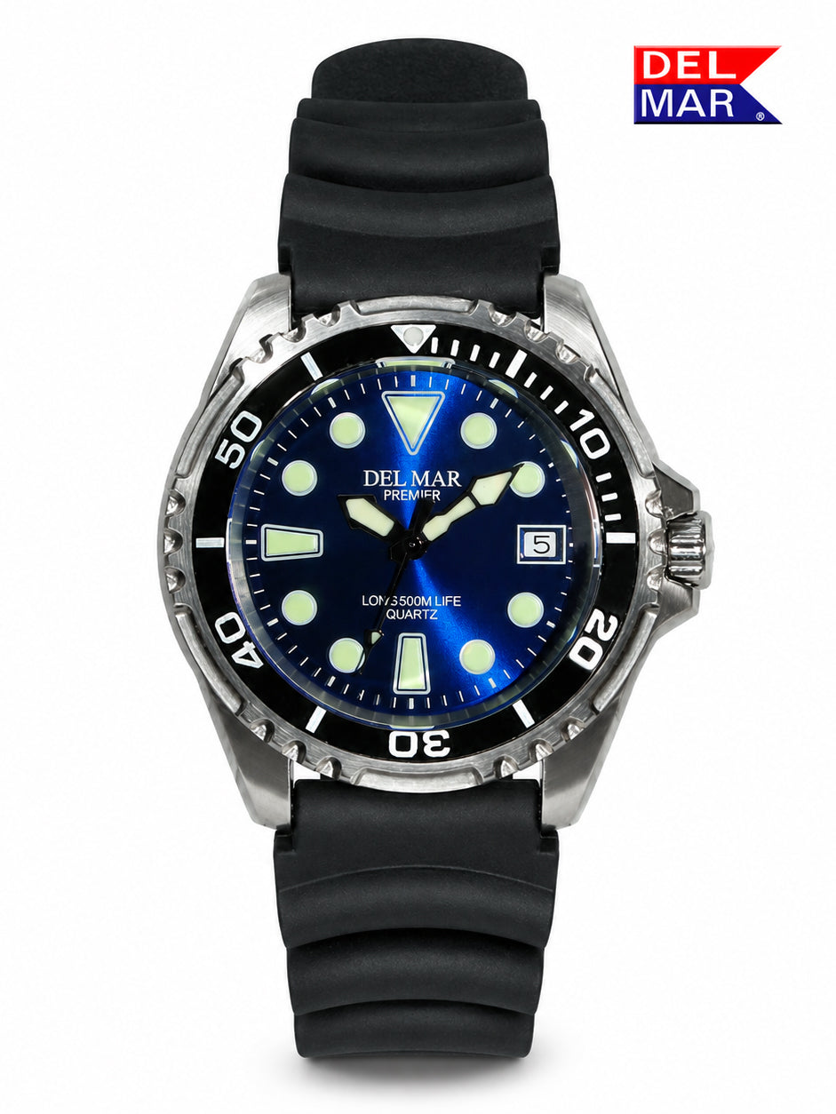 A Del Mar Premier wristwatch with a blue dial, silver-tone stainless steel case, and a black textured silicone strap, shown against a plain white background with a Del Mar logo in the top right corner.